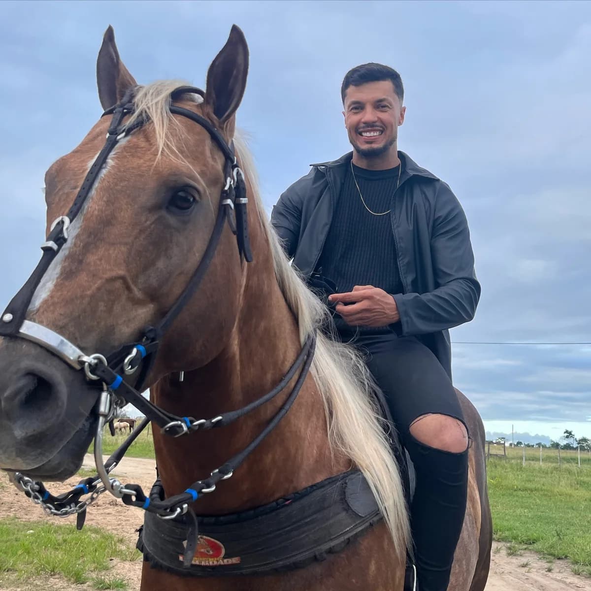 O dono da Reis Store, a cavalo, no campo